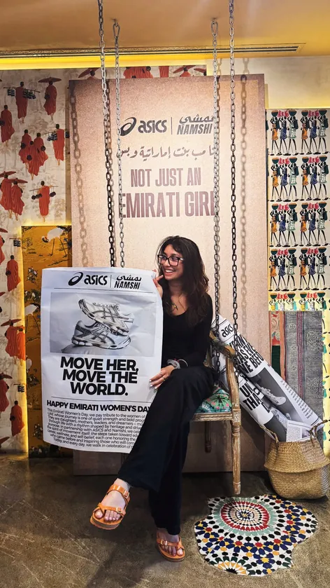 Aditi at the ASICS and Namshi Emirati Women’s Day event, holding a co-branded “Move her, move the world” gift bag.